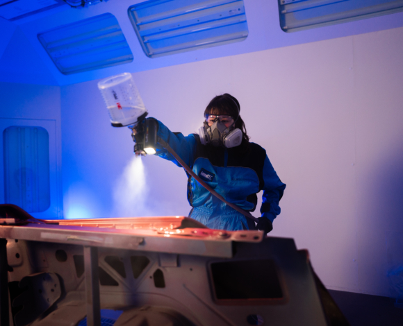 female student spraying a car with a spray gun