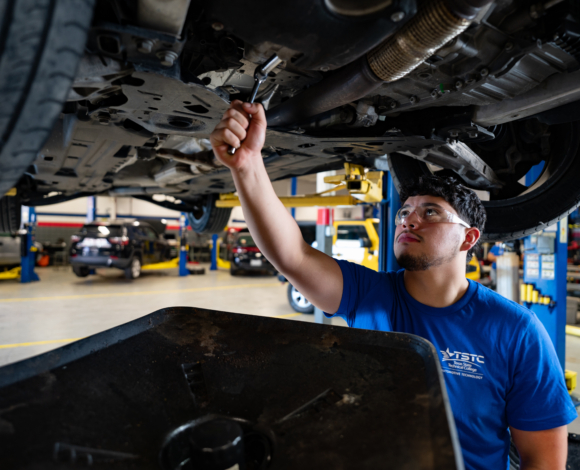 a student working under a car