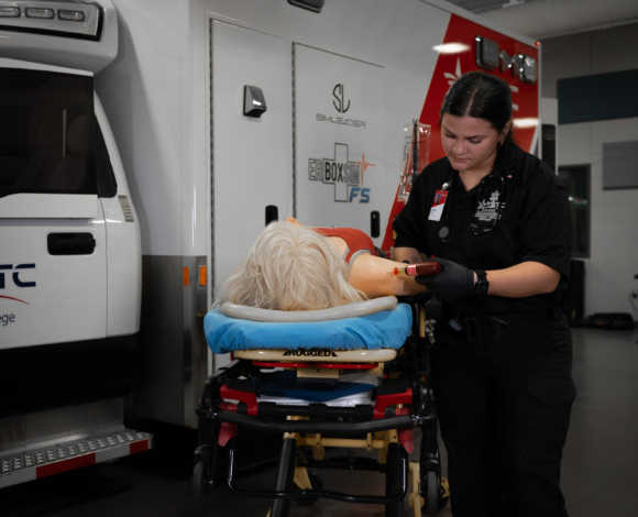 EMS student working in ambulance simulator.