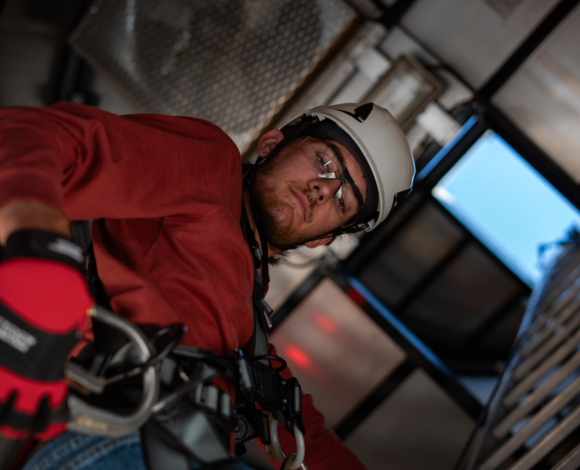 a wind energy student wearing a helmet and harness